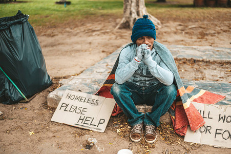 一个人坐着一个无家可归的乞丐请图片