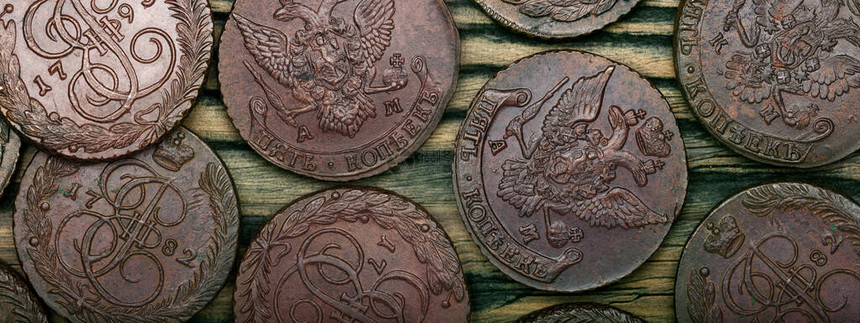 古老的收集硬币用旧木制桌上的铜制图片