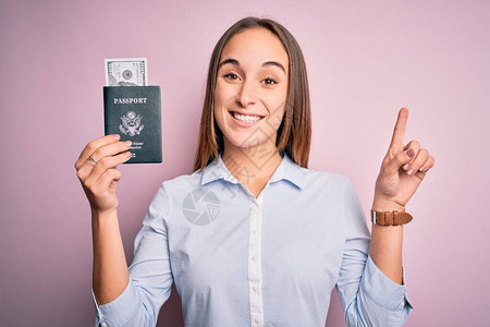 度假的旅游女客持有带美元钞票的护照图片