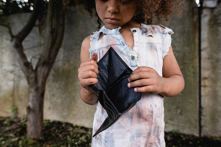 贫穷的非洲裔美国儿童在城市街上空钱包图片