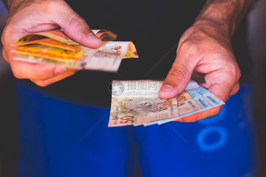 男人检查五十一百二十雷亚尔的钞票来自巴西的钱和图片