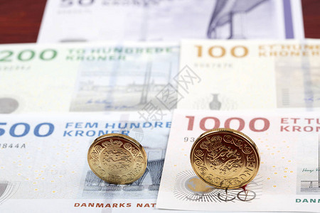 在钞票背景的丹麦硬币背景图片