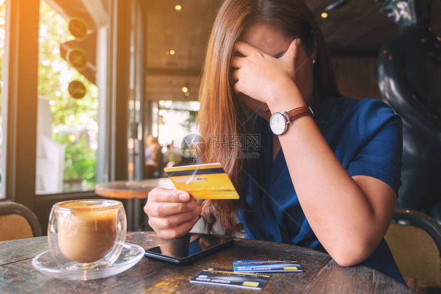 一个亚裔女在持有信用卡时紧张和破碎