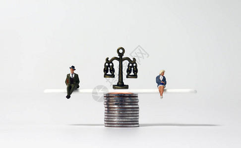 微型人和成堆的硬币男女经济平等的概念图片