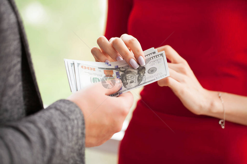 商业女商人给男人钱穿红裙子的女人行贿灰色夹克的商人得到贿图片
