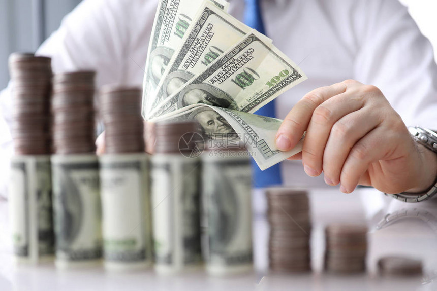 对男计算金钱的近视选择地以钞票关注手边增加桌面上的硬币堆叠商业和财务利润图片