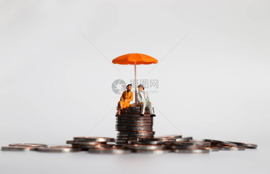 一对年长的小型夫妇坐在一块硬币上带图片