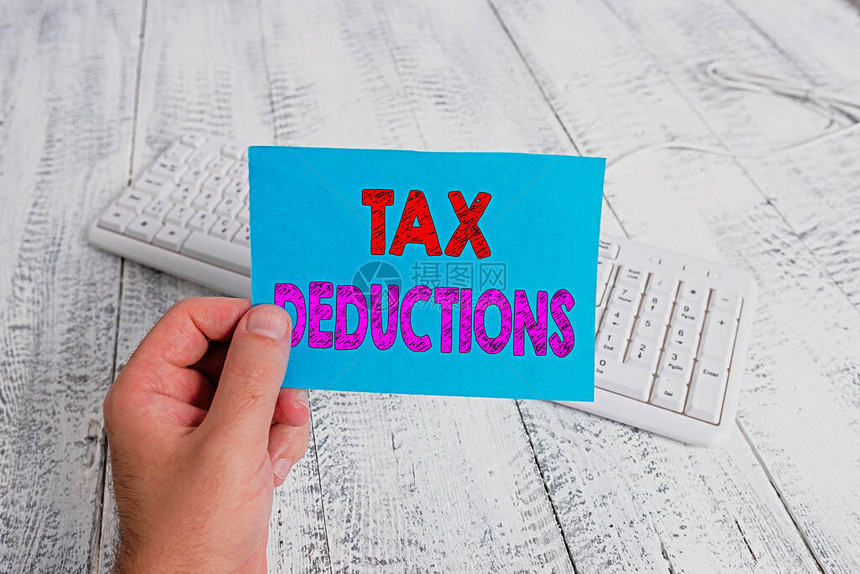 缩略语文字写作税务减税概念照片从某人身上减去的金额或成本是持彩色提醒方形纸型白键盘木地板图片