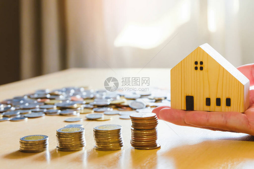 木桌上的硬币堆储蓄计划购买房产房屋拥有房子的个人财务概念带有文图片