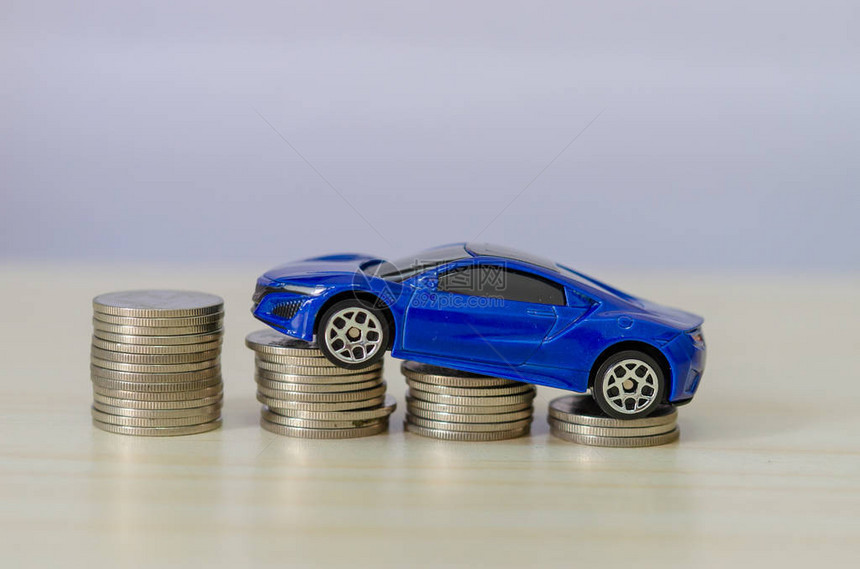 成堆的硬币上的汽车模型金融概念图片
