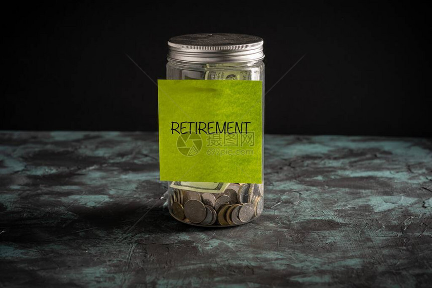贴在装满硬币的罐子上的纸上的退休措辞图片