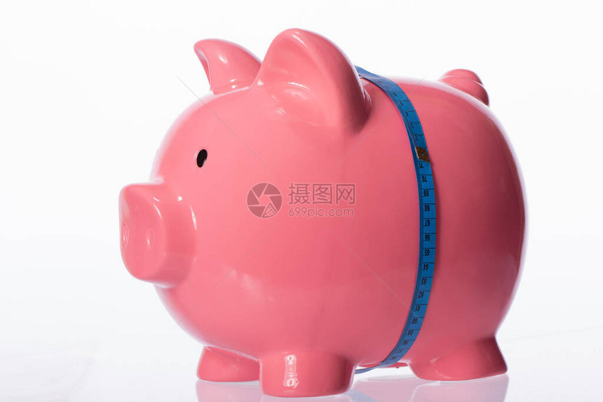 粉红色的大存钱罐在腰部用蓝色卷尺绑在白色背景上储蓄概念健身和饮食概念梦想苗条的身材停止希望开始做概图片