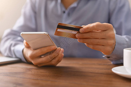 在工作场所用信卡和智能手机在网上购物的无法识别的图片