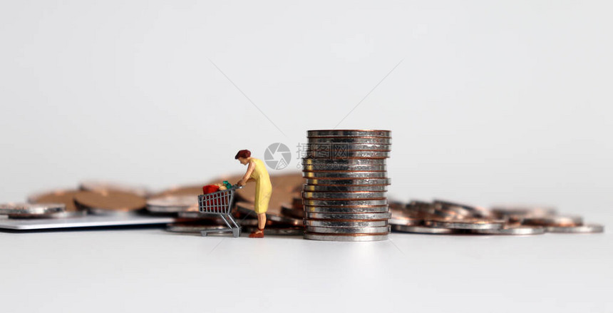 一个拖着硬币和购物车的微型女人图片