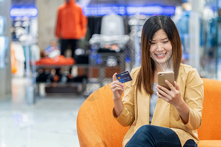 亚洲女在使用信卡信用卡模型在线支付概念在线购物时图片