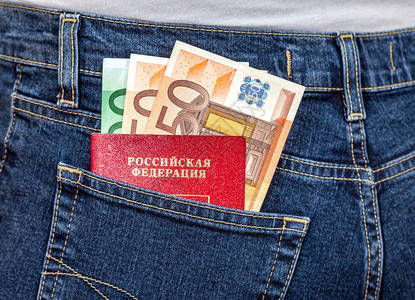 后牛仔裤口袋中的俄罗斯护照和欧元钞票图片