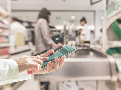 数字生活方式商务人士或购物者使用移动智能手机在超市收银柜台图片
