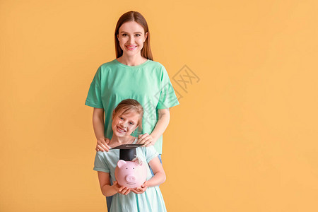 女孩和母亲在彩色背景教育方面有储蓄的图片