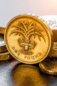 英国硬币堆在黑色英镑上图片