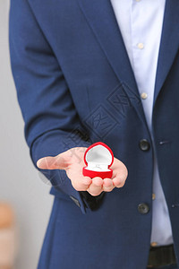 男人拿着订婚戒指的盒子特写图片