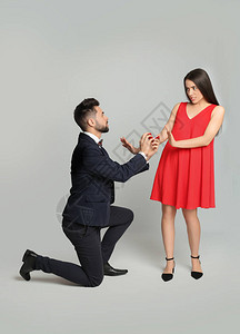 年轻女子以浅灰色背景拒绝男友订婚戒指图片