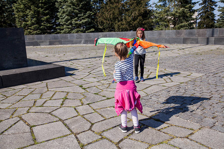 两个小女孩在春天的公园里和两个女孩玩得开心与多彩的飞图片