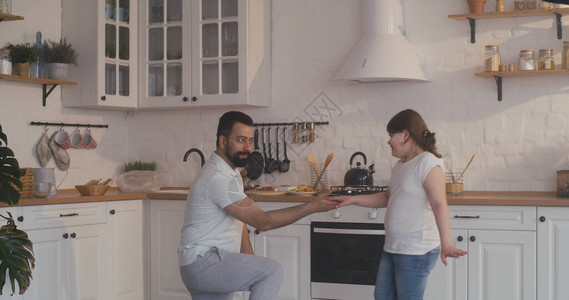一个父亲和女儿在厨房里跳图片