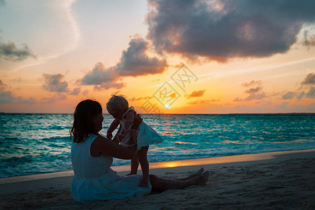 快乐的母亲和小女儿在日落图片