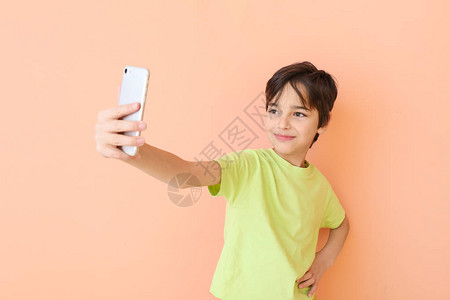 可爱的小男孩在彩色背景上自拍图片