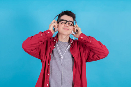 蓝底带耳机的年轻青少年男子图片