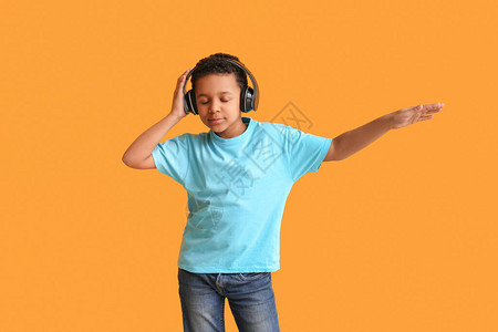 非裔美国男孩在彩色背景下听音乐和跳舞的非洲图片
