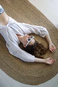 美丽的女人躺在地板上时装女孩穿着白衬衫和白墨镜图片