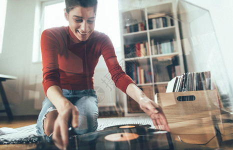 年轻听力哲学青年享受音乐在家中的转盘中玩黑乙烯基唱片图片
