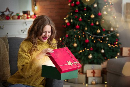 快乐的年轻姑娘在家开圣诞礼物时打开神图片