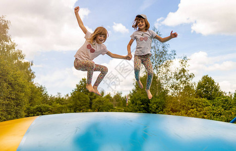 快乐的孩子们跳上充气蹦床图片