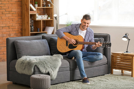 英俊的男人在家弹吉他图片