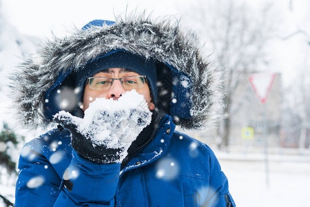 男人手里拿着雪吹着它图片