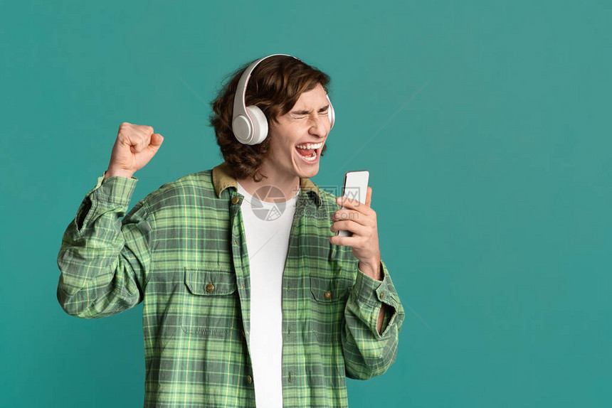 戴耳机的特伦迪青少年使用智能手机作为麦克风图片