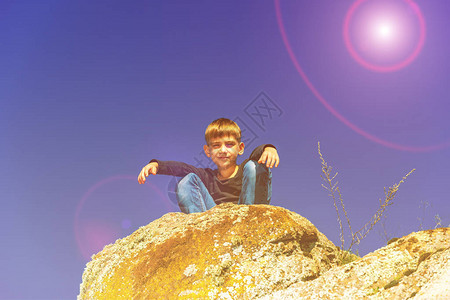 男孩蹲在悬崖顶上往下看图片