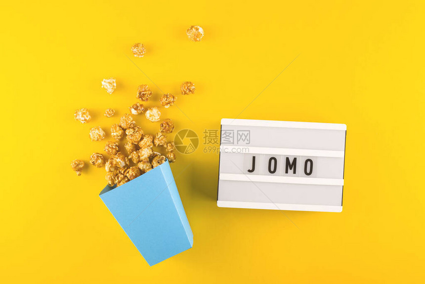 缩写词JOMO写在明亮的黄色背景上的装饰板上从信息和小工具中放松的概念图片