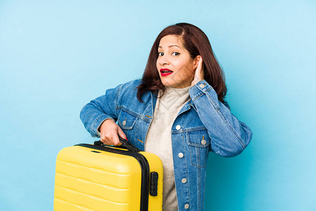 Middlr年龄的拉丁旅行者女人拿着一个手提箱孤图片