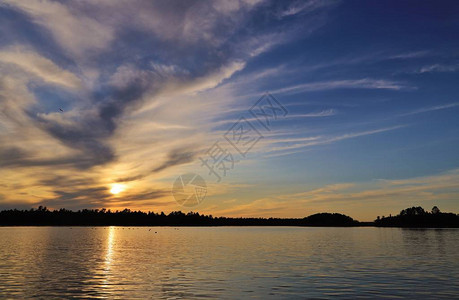 日落时分多云的天空下的湖景图片
