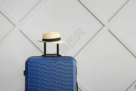 靠近光墙的手提箱和帽子旅游理念图片