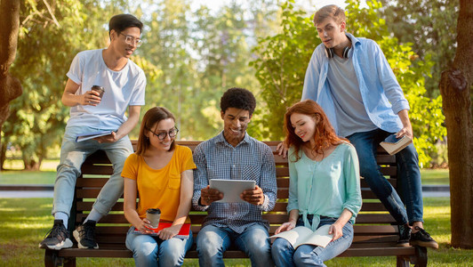 学生活方式多民族的大学朋友下课后一起坐在公园户外图片