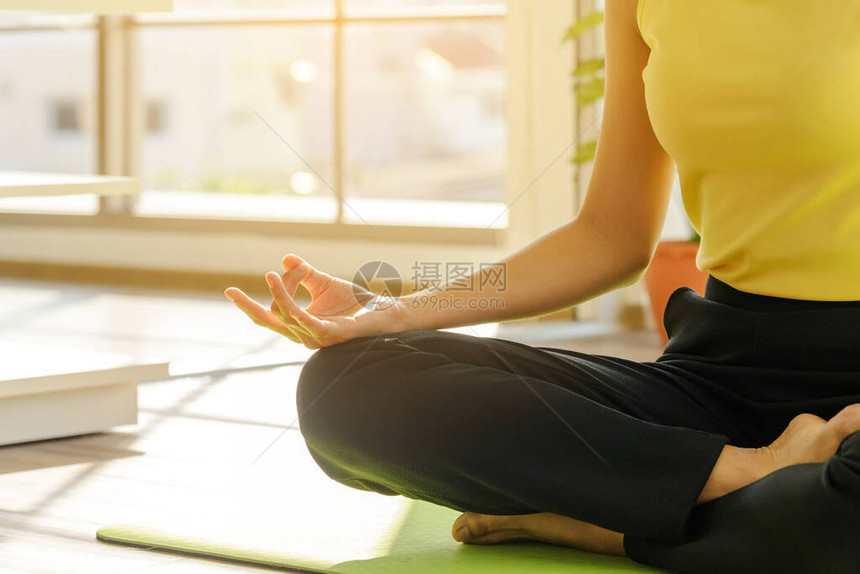 当亚洲女练习瑜伽课呼吸在家客厅冥想时图片