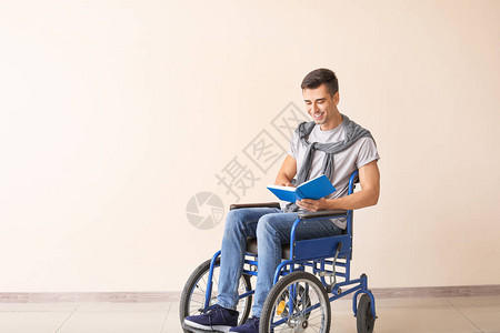 穿着轮椅阅读书的残疾青年男图片