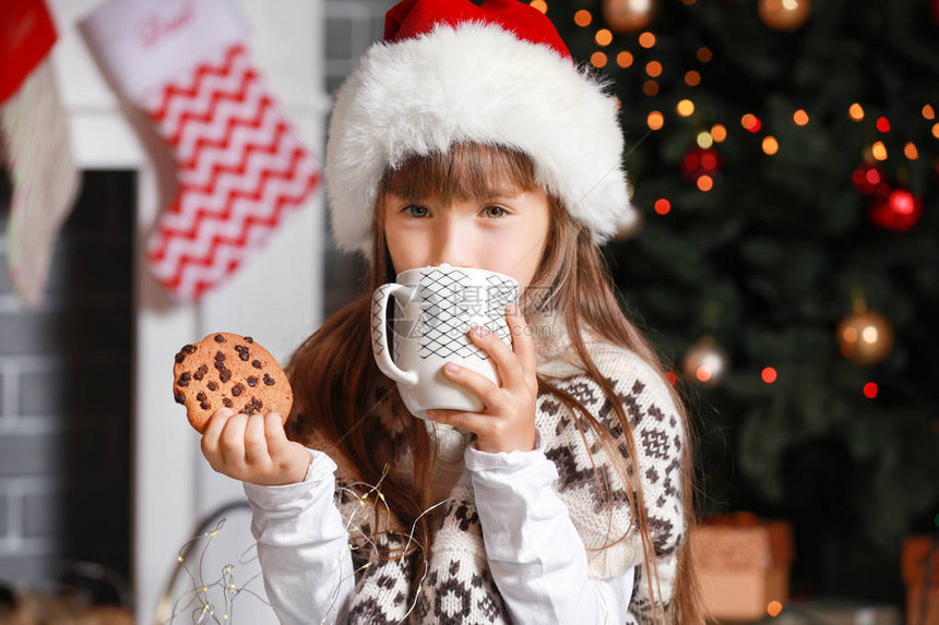 圣诞节前夕在家吃热巧克力和饼干的小女图片