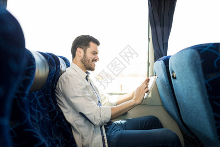 乘坐公共汽车时使用数字平板的图片