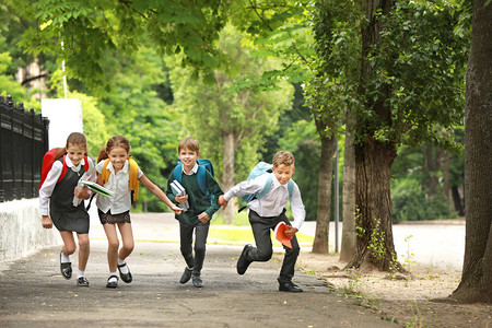 可爱的小学生在户外跑步图片