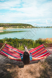 女人躺在吊床上享受夏季湖间复图片